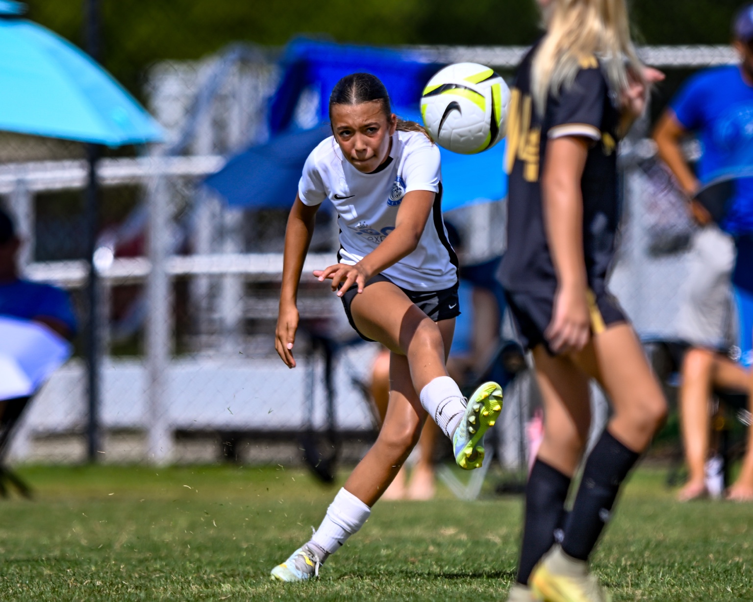 Pierce Jackson in a white kit striking the ball during a match.