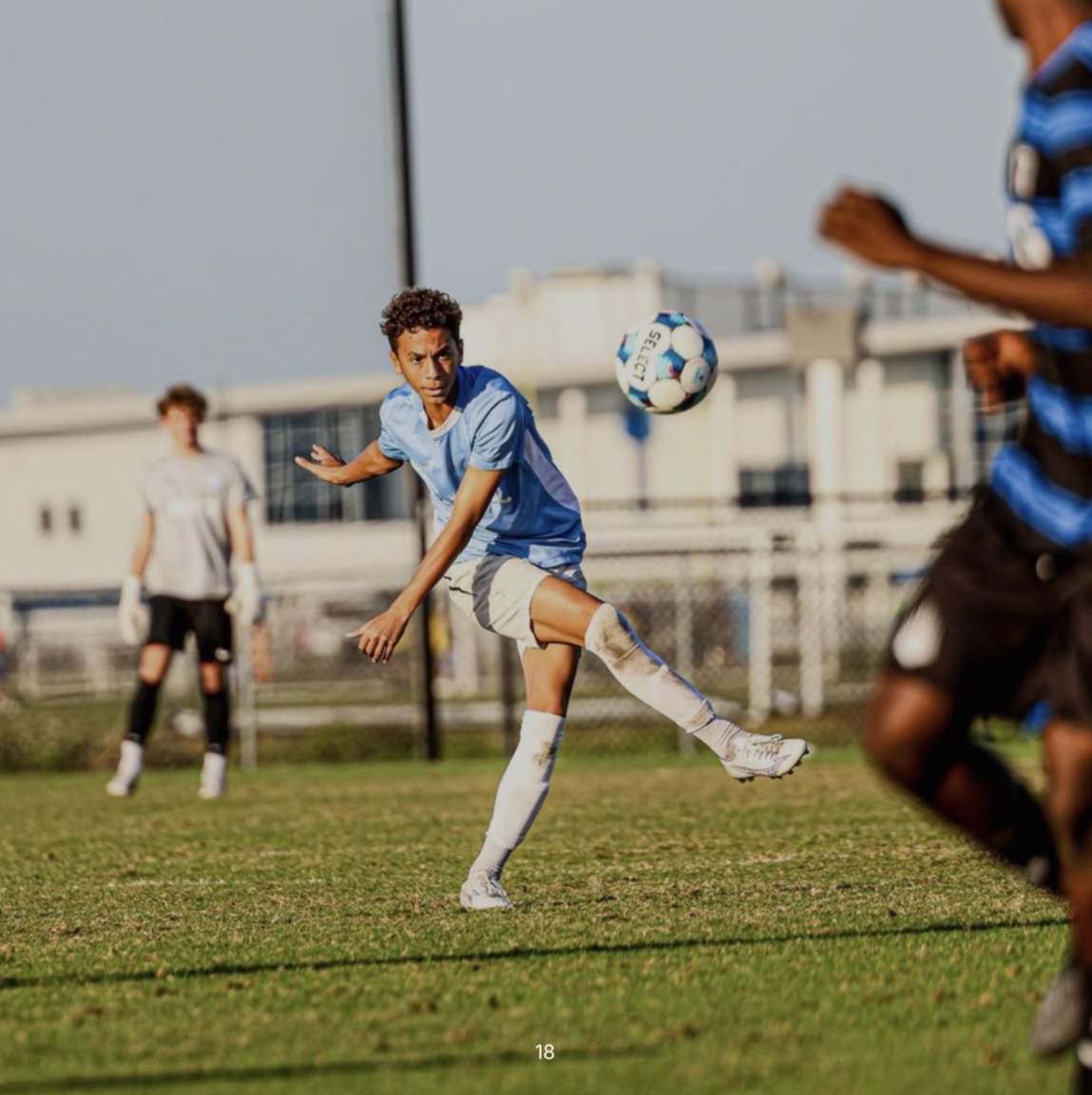 Kruz Jackson in a light-blue kit striking the ball during a match.